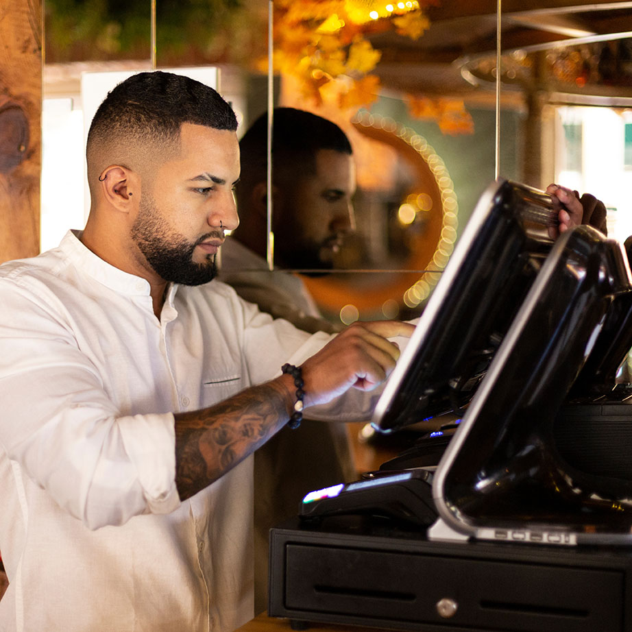 Young Latino worker in small business preparing the bill at the
